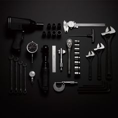 various tools are laid out on a black surface, including hammers, wrenches and other items