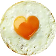 an egg in the shape of a heart on top of a fried egg with yolks