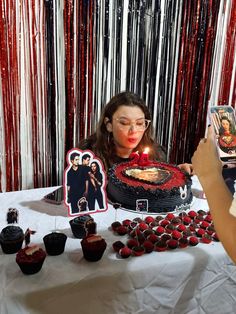 a woman is blowing out candles on a cake