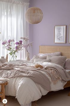 a bedroom with purple walls and white bedding in the center is decorated with lavender flowers