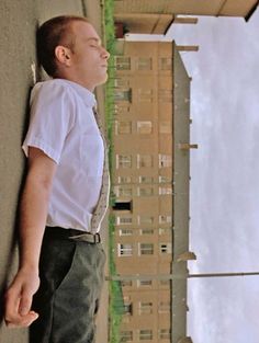 a man leaning against a wall with his eyes closed