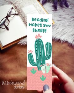 someone is holding up a card that says reading makes you sharp with a cactus on it