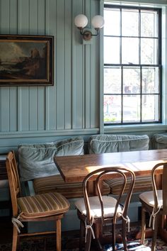 a table and chairs in a room with blue walls