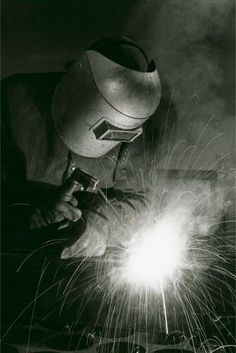 welder in black and white working with sparks