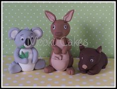 three small figurines of koalas and a kangaroo on a polka dot tablecloth