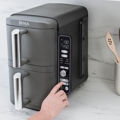 a person pressing buttons on a ninja toaster