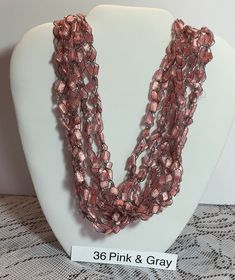 a pink and gray beaded necklace on display