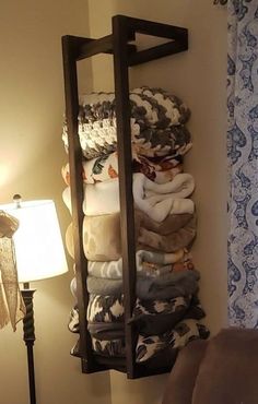 there is a rack with towels on it in the corner next to a lamp and window