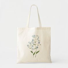 a tote bag with blue flowers on the front and bottom, sitting against a white background