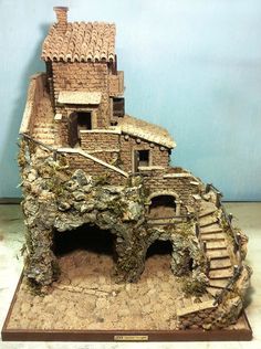 a model of a house made out of rocks and stone bricks with stairs leading up to the roof