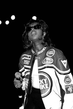 a black and white photo of a woman singing into a microphone