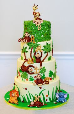 a three tiered cake decorated with monkeys and other animals on it's sides