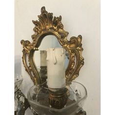 a candle is sitting on top of a glass bowl with a mirror in the background