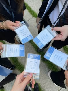 four people are holding their id cards in front of each other while sitting on the ground