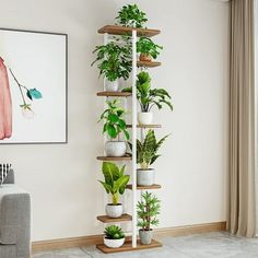 a living room filled with lots of plants next to a painting on the wall and a couch