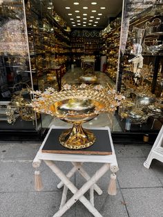 a gold plate on a table in front of a store window with other items behind it