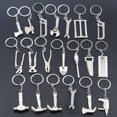 many different types of tools are shown on a black surface with silver keychains