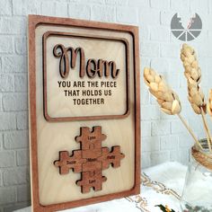 a wooden puzzle with the words mom you are the piece that holds us together