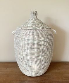 a large white basket sitting on top of a wooden table