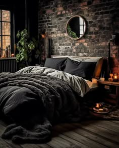 a bedroom with brick walls and wooden flooring is lit by candle lights in front of the bed