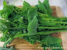 some green vegetables are laying on a cutting board