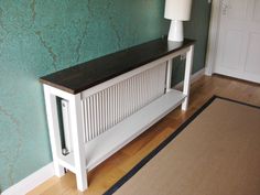 a white radiator sitting on top of a wooden floor next to a lamp