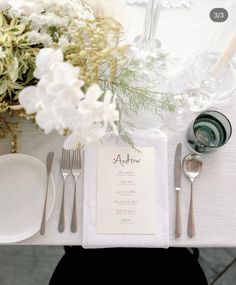 the place setting is set with silverware and flowers