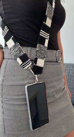 a woman wearing a black and white checkered skirt with a cell phone in her pocket