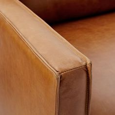 the back end of a brown leather couch with stitching on it's sides