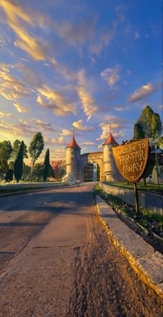 a sign that is sitting on the side of a road in front of a castle