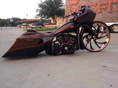 a brown motorcycle parked on top of a parking lot