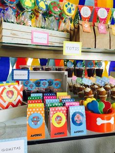 there are many colorful cupcakes on display at the market stall with price tags