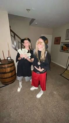 two women dressed up in costumes standing next to each other with money on their hands