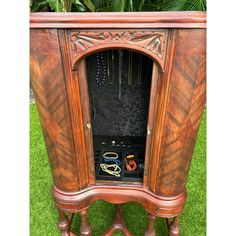 an old fashioned wooden jewelry cabinet in the grass