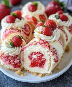 a white plate topped with cake covered in cream and strawberries next to sliced strawberries