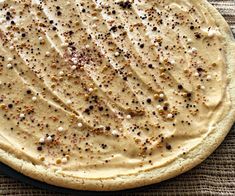 an uncooked pizza sitting on top of a pan covered in cheese and seasoning