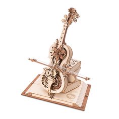 a wooden model of a violin on top of a book