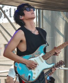 a man with sunglasses playing an electric guitar