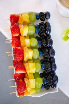 fruit skewers are arranged in the shape of a rainbow