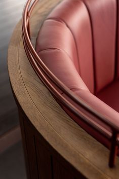 a red leather chair sitting on top of a wooden table