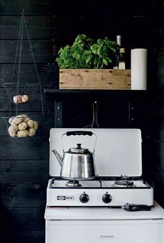 a white stove top oven sitting inside of a kitchen next to a potted plant