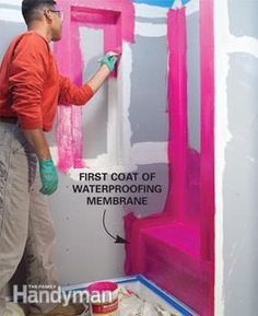 a man painting the wall with pink paint