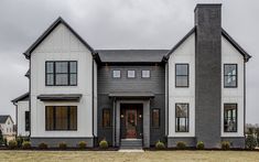 a large gray and white house on a cloudy day