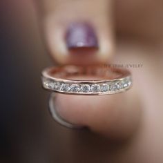 a woman's hand holding a wedding ring with five diamonds on the inside of it