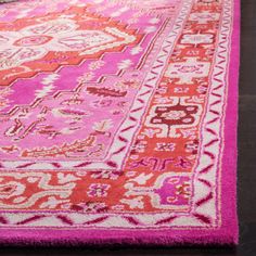 a pink and red rug on top of a wooden floor