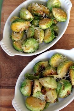 two white bowls filled with brussel sprouts on top of a wooden table