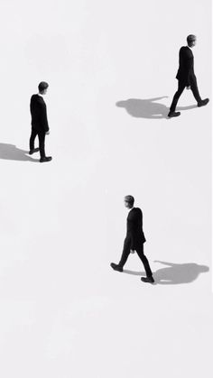 three people walking across a snow covered field