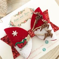 a red and white bow with reindeers on it sitting on top of a piece of paper