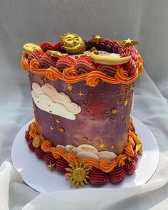 a cake decorated with clouds, stars and sun on top of a white platter