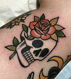 a skull and rose tattoo on the arm